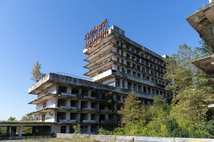 Verlaten gebouw met graffiti en een heldere lucht op de achtergrond.